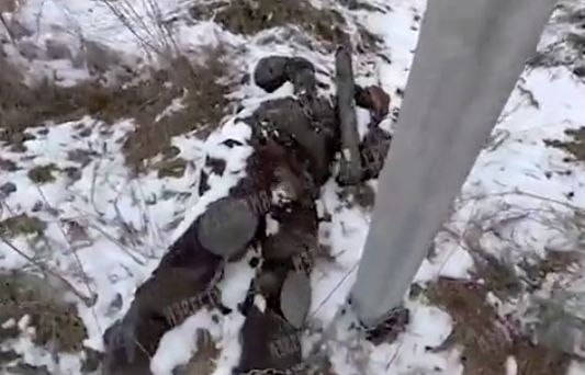 Брутално ВИДЕО 18+ на загинал украински войник, прикован с верига за стълб, от националистите, за да не може да отстъпи