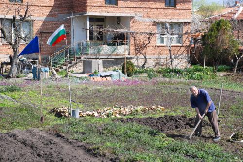 Патриот копае в градината си под националния флаг
